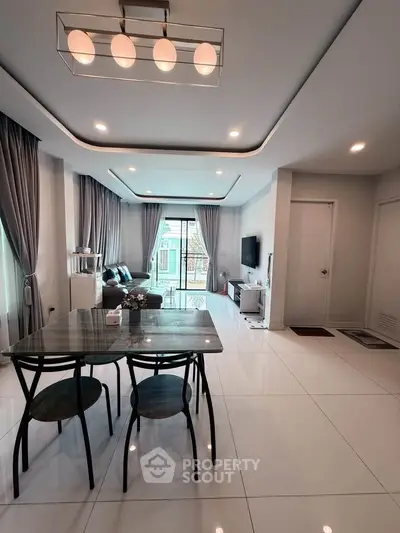 Modern living room with elegant decor and spacious layout, featuring a stylish dining area and large windows.