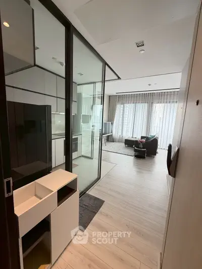 Modern open-layout living room with glass partition and sleek furnishings