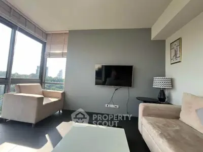 Modern living room with large windows and stylish furniture, offering a bright and inviting atmosphere.