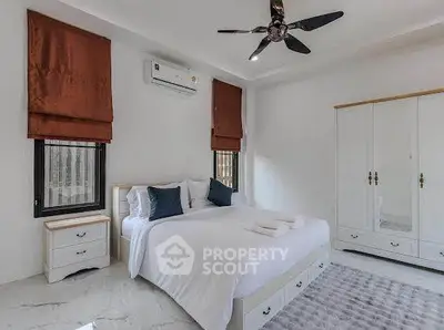 Spacious bedroom with modern decor, featuring a comfortable bed, air conditioning, and ample storage space.