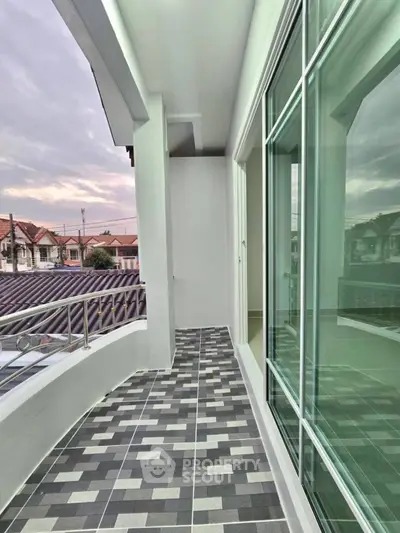 Charming balcony with modern tiles and glass doors offering a serene neighborhood view.