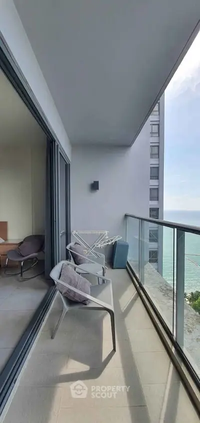 Spacious balcony with ocean view in modern high-rise apartment