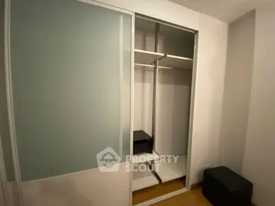 Spacious modern closet with sliding doors in a well-lit room, perfect for organized storage solutions.