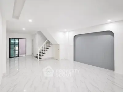 Spacious modern living room with elegant staircase and sleek marble flooring