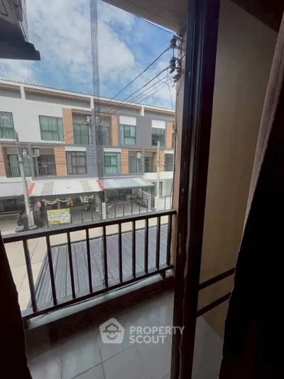 Charming balcony view of modern townhouses with clear blue sky.