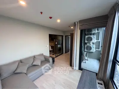 Modern living room with large windows and cozy sofa in a stylish apartment.