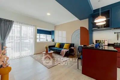 Stylish modern living room with open kitchen, vibrant decor, and natural light.