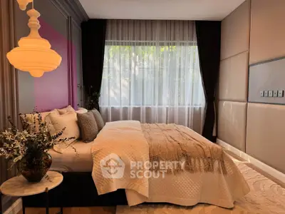 Luxurious bedroom with elegant decor and large window for natural light.