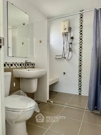 Modern bathroom with shower and stylish tile accents in a real estate property.