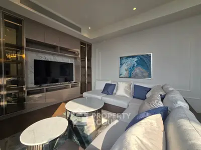Luxurious modern living room with elegant sectional sofa and large TV, perfect for relaxation.