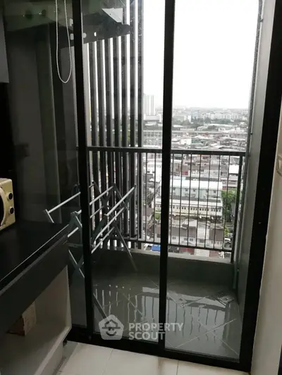 Modern apartment balcony with city view and glass sliding doors