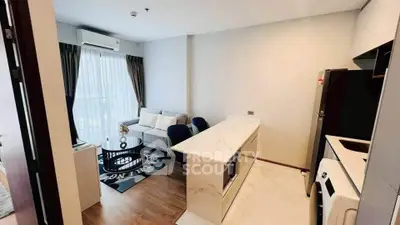 Modern open-plan living room and kitchen with stylish decor and natural light.