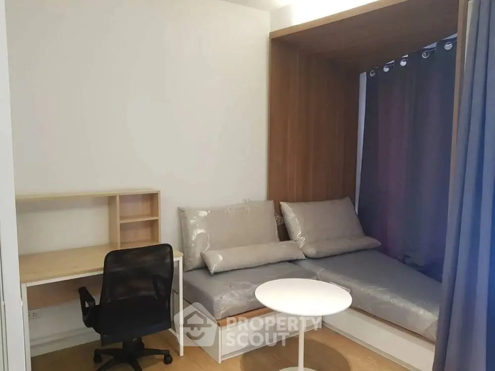 Modern studio apartment with cozy workspace and convertible sofa bed.