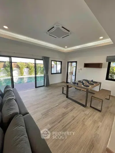 Spacious living room with pool view and modern dining area