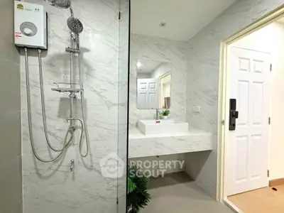 Modern bathroom with sleek shower and elegant sink in stylish real estate property.