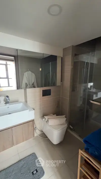 Modern bathroom with glass shower and sleek fixtures in a contemporary home.