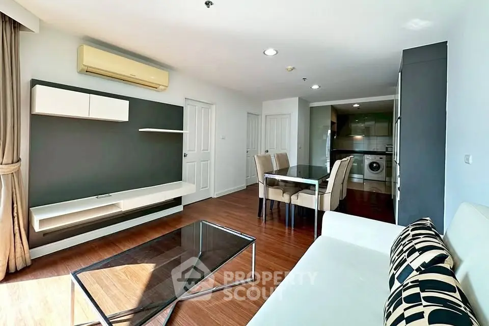 Modern living room with sleek furniture and open kitchen layout in a stylish apartment.