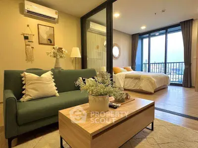 Modern open-plan living room and bedroom with stylish decor and balcony view.