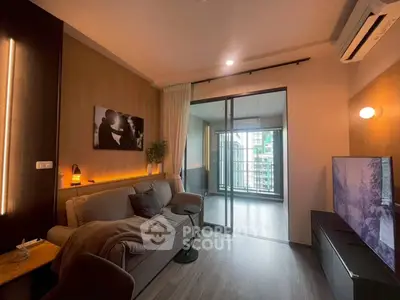 Modern living room with cozy sofa, stylish decor, and sliding glass doors leading to a balcony.