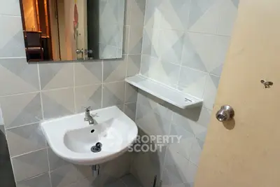 Compact bathroom with modern sink and geometric tile design