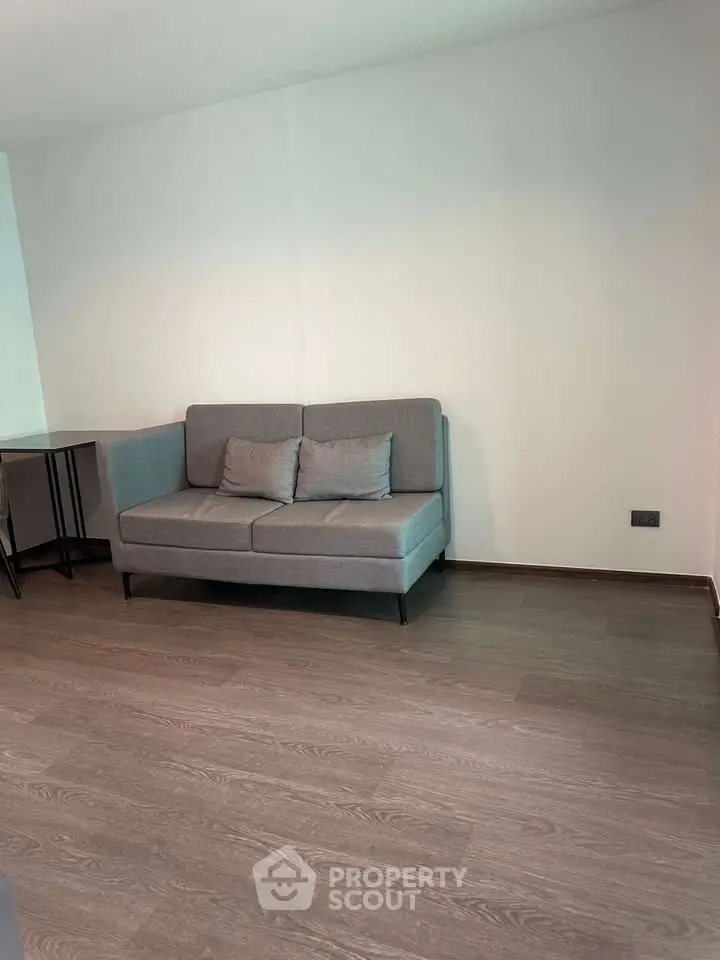 Modern living room with stylish gray sofa and wooden flooring