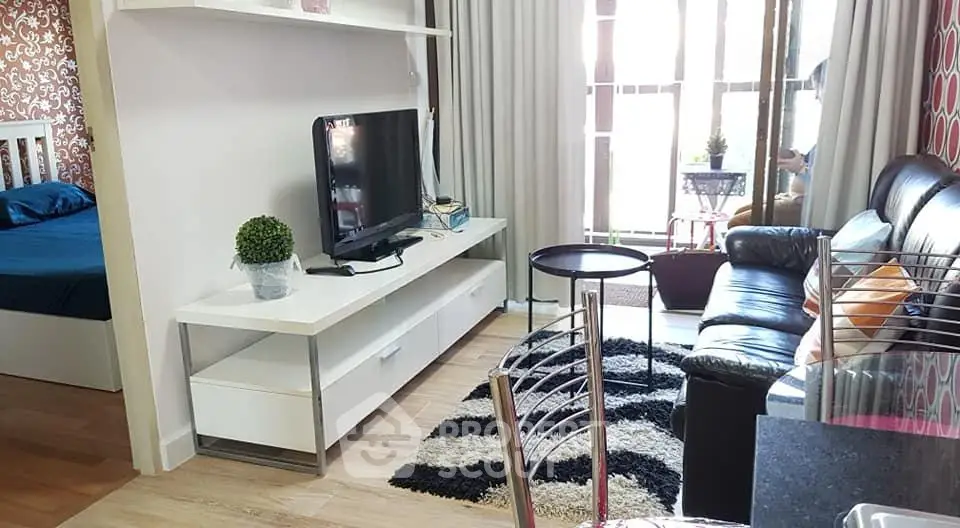Modern living room with stylish decor and natural light, featuring a cozy seating area and entertainment setup.