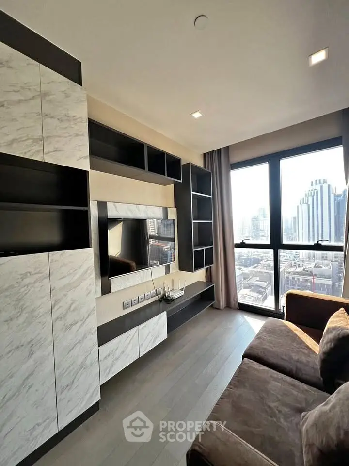 Modern living room with built-in shelving and city view through large windows.