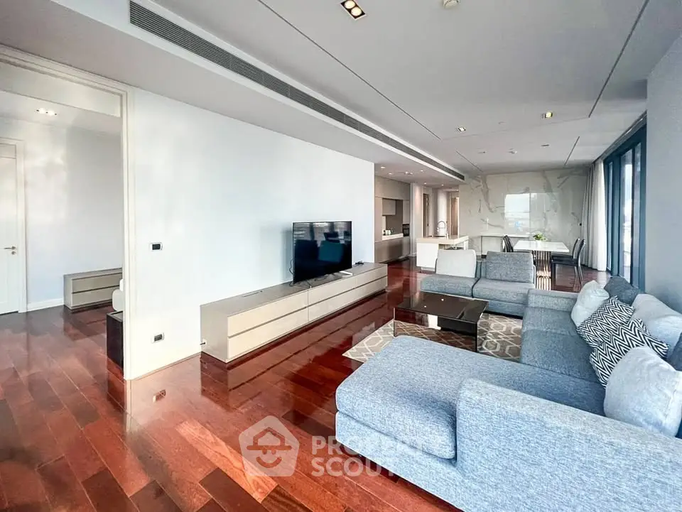 Spacious modern living room with sleek hardwood floors and stylish furniture in luxury apartment.