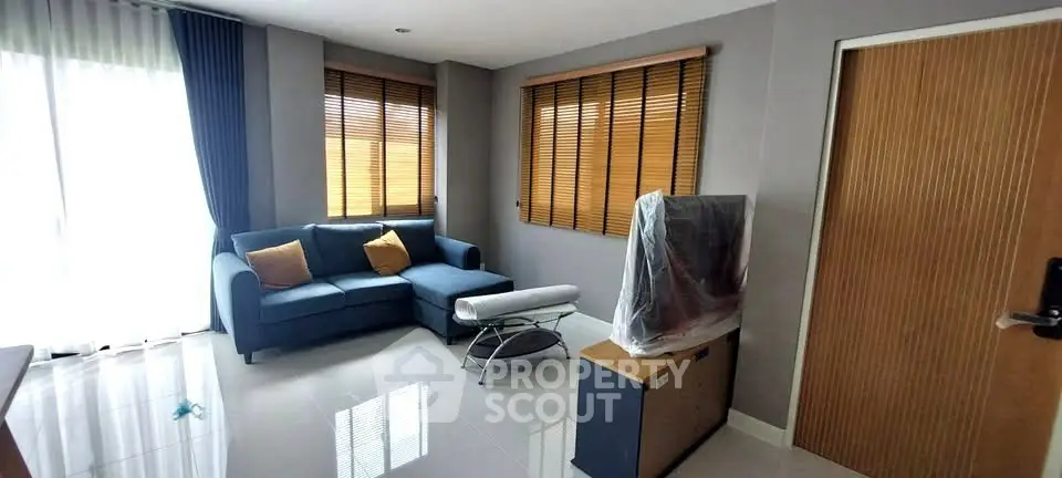 Modern living room with stylish sofa and covered TV in a bright apartment