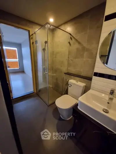 Modern bathroom with glass shower and sleek fixtures in a contemporary apartment.