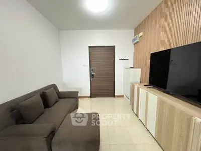 Modern living room with sleek furniture and large TV, perfect for relaxation.