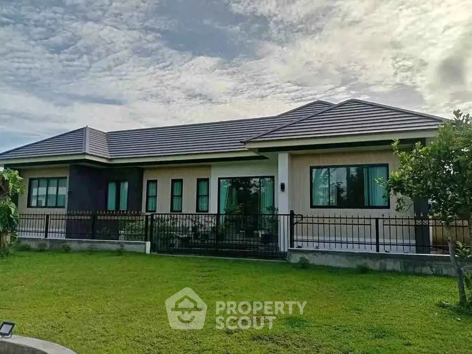 Charming single-story home with modern roof and lush green lawn, perfect for family living.