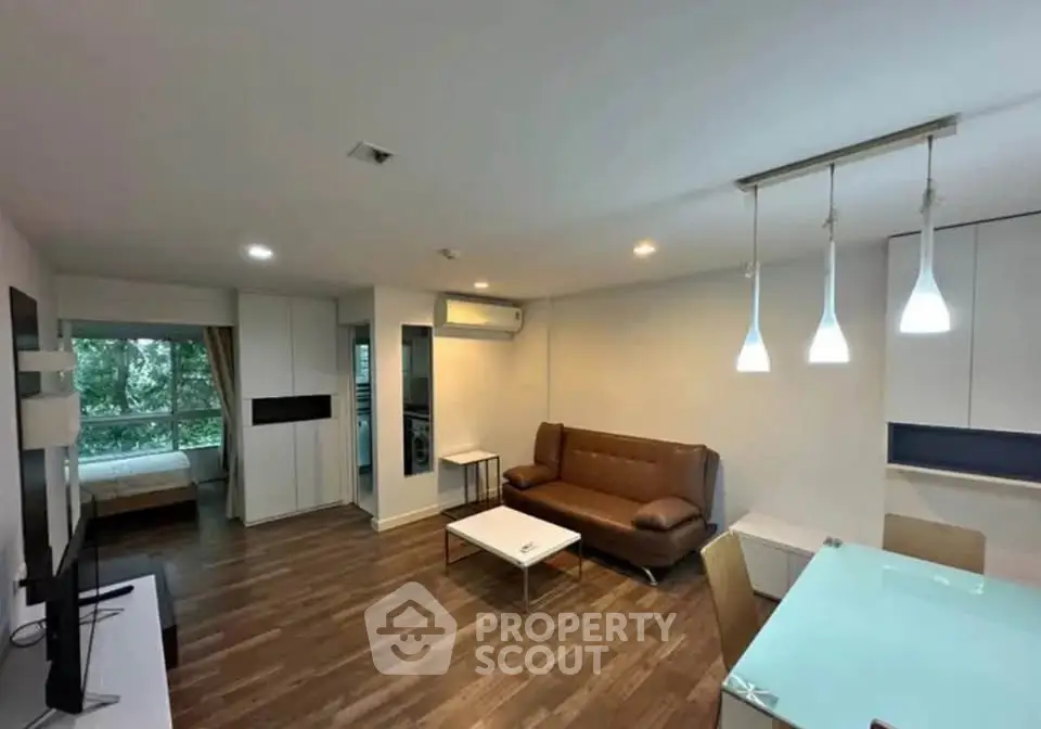 Modern living room with stylish furniture and open layout, featuring a cozy sofa and elegant lighting.