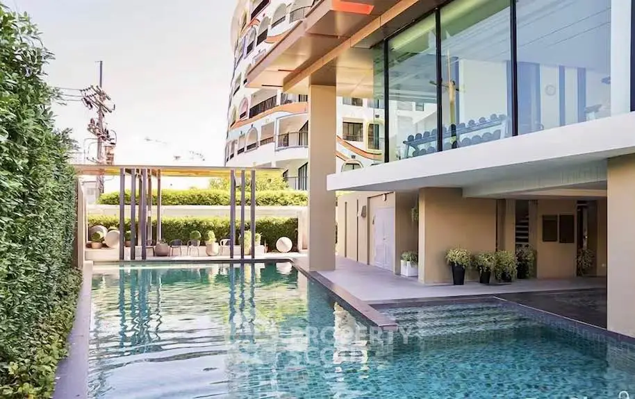 Luxurious modern apartment with stunning poolside view and elegant architecture.