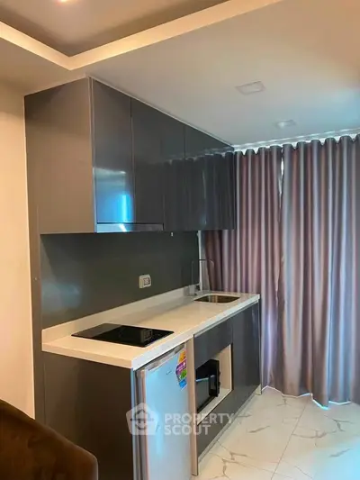 Modern kitchen with sleek cabinetry and compact appliances in a stylish apartment.