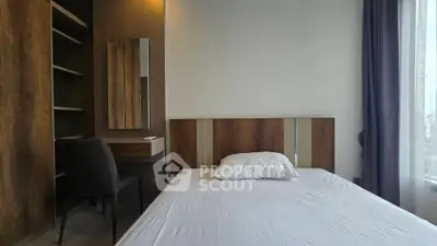 Modern bedroom with minimalist design, featuring a comfortable bed, stylish wooden accents, and a cozy workspace.