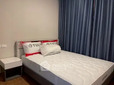 Cozy bedroom with modern bed and nightstand, featuring stylish curtains.