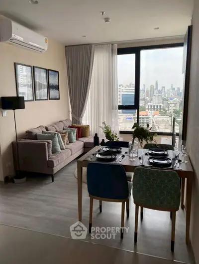 Modern living room with city view, stylish decor, and dining area in a high-rise apartment.