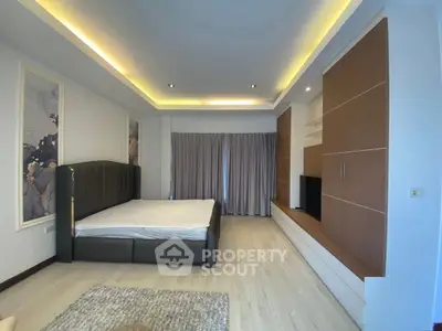 Spacious modern bedroom with elegant lighting and built-in storage