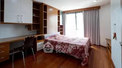 Spacious bedroom with wooden flooring and built-in shelves, perfect for modern living.