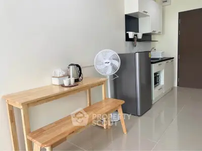 Modern compact kitchen with sleek appliances and wooden dining set, perfect for cozy living.