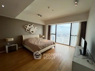 Luxurious bedroom with stunning city view and modern decor in high-rise apartment.