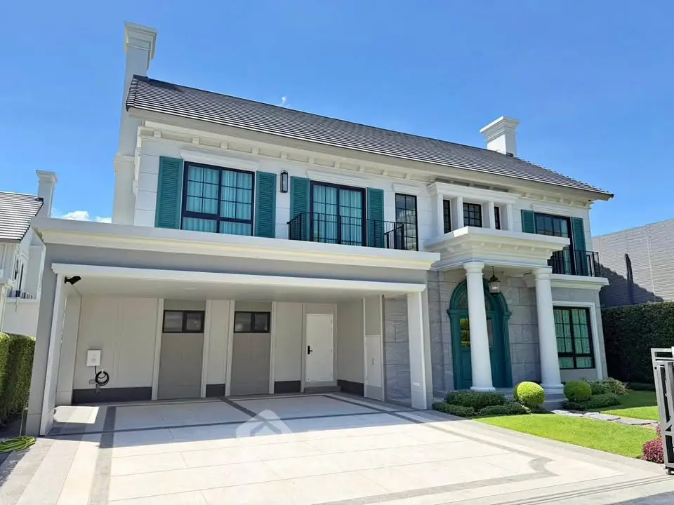 Luxurious two-story house with elegant columns and spacious driveway, perfect for upscale living.