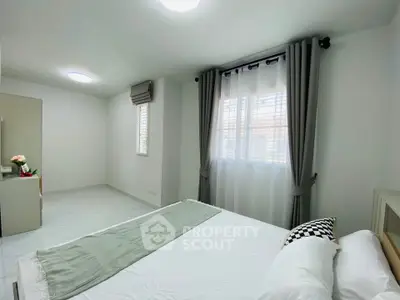 Spacious and bright bedroom with modern decor and large windows in a stylish home.