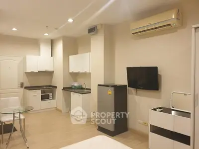 Modern studio apartment with open kitchen and sleek appliances, perfect for urban living.