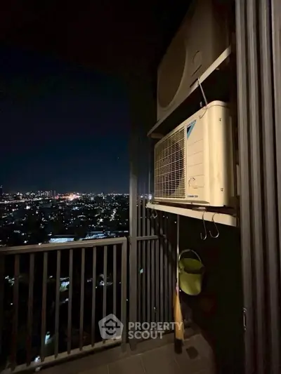 Stunning night city view from a high-rise balcony with air conditioning unit.