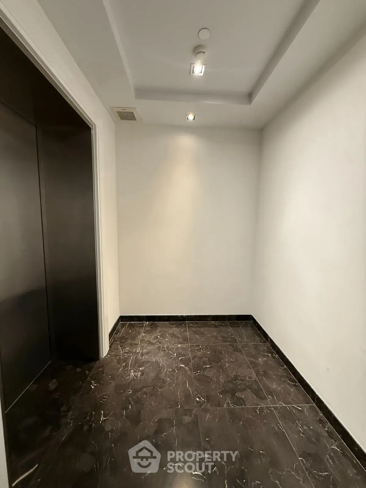 Modern elevator lobby with sleek marble flooring and recessed lighting