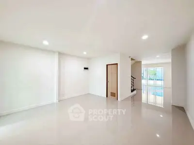 Spacious empty living room with glossy floors and natural light