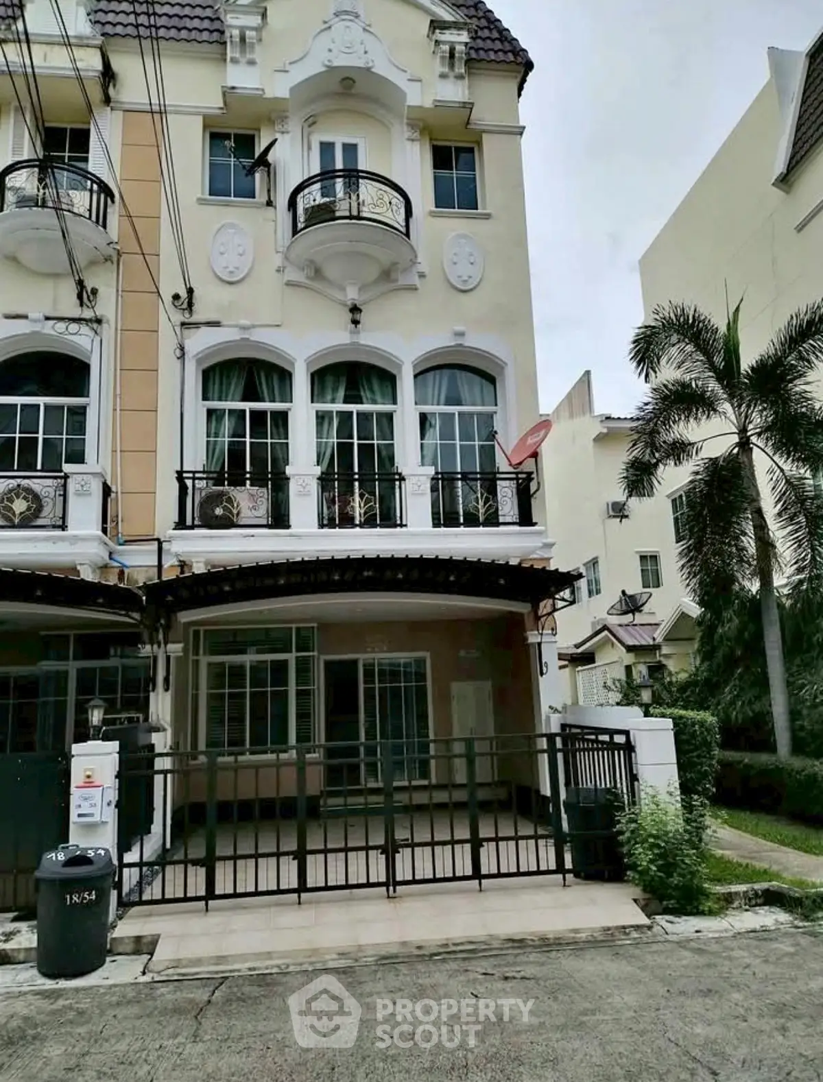 Charming three-story townhouse with elegant facade and balcony in a serene neighborhood.