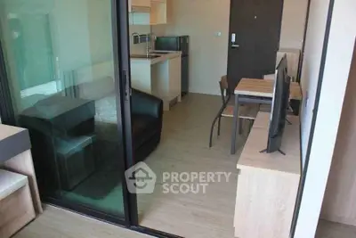 Modern apartment interior with open layout, featuring a cozy living area and compact kitchen.